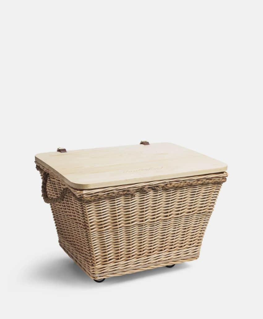 A rectangular wicker basket with a flat wooden lid and two rope handles, set against a plain white background.