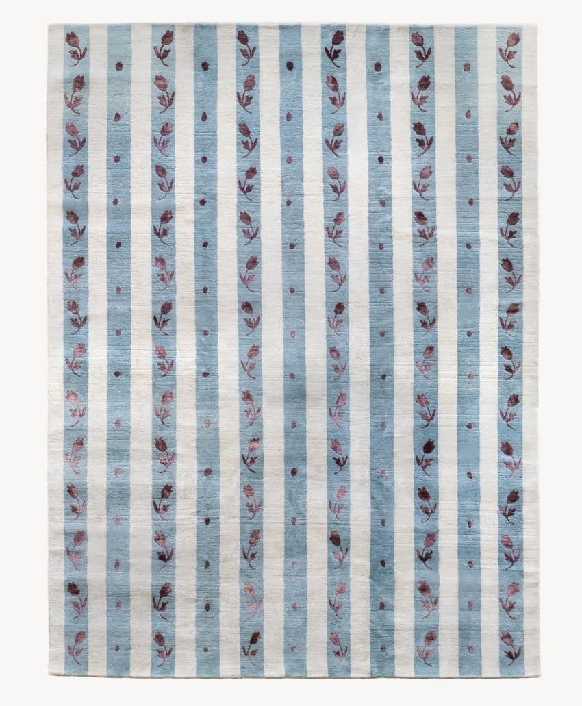 A rectangular rug featuring alternating vertical stripes of light blue and off-white, with the blue stripes decorated with pink and red floral motifs—a timeless home style perfect for unique finds sought by interior designers.