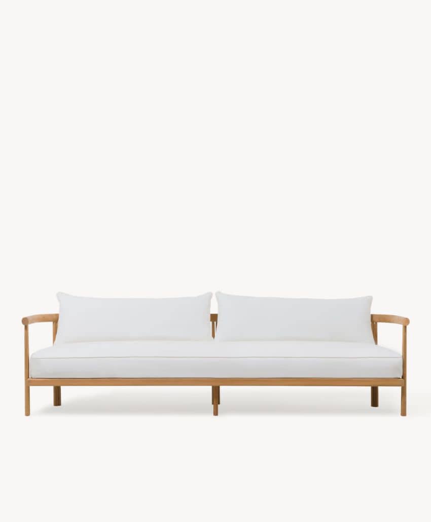 A minimalist wooden-framed sofa with simple lines, featuring white seat and back cushions set against a plain white background.