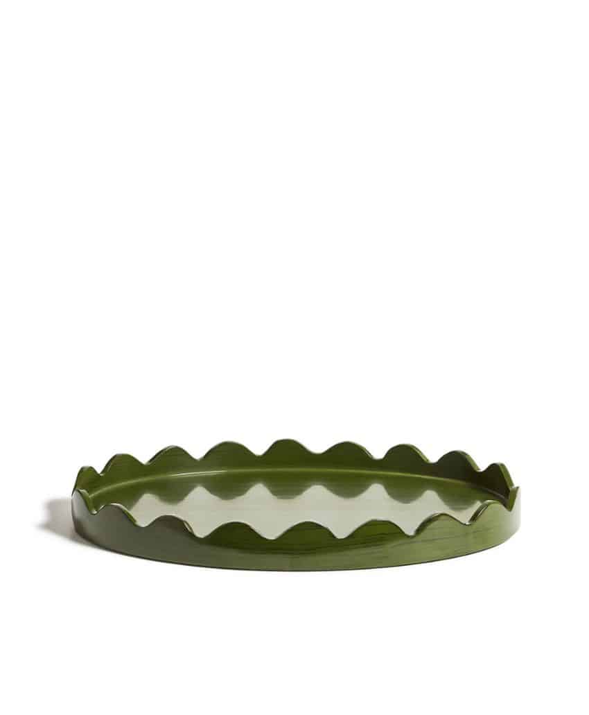 A round, green tray with a glossy surface and scalloped, wavy edges, placed on a white background.