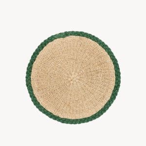 A round woven placemat made of natural fibers, featuring a tan center and a green braided border, displayed on a plain white background.