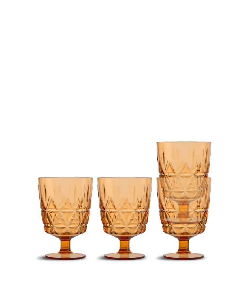 Four amber-colored, patterned glass goblets are shown, three stacked inside each other on the right and one standing alone on the left, all with short stems and wide bowls against a white background.