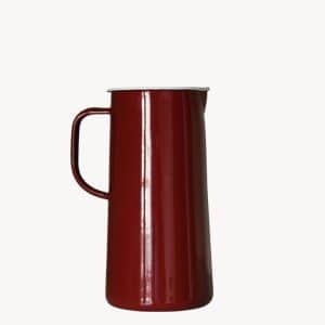 A tall, red enamel pitcher with a handle and a spout, set against a plain white background.