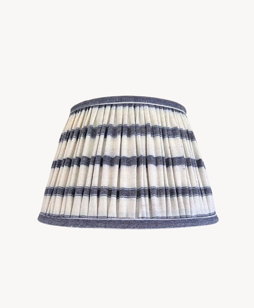 Pleated lampshade with horizontal navy blue and white stripes, set against a plain white background.
