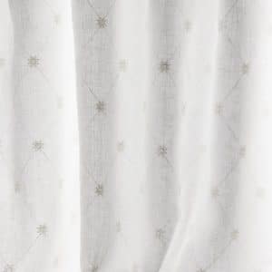 Sheer white curtain with a subtle diamond grid pattern and small embroidered floral motifs at each intersection, allowing soft light to filter through.
