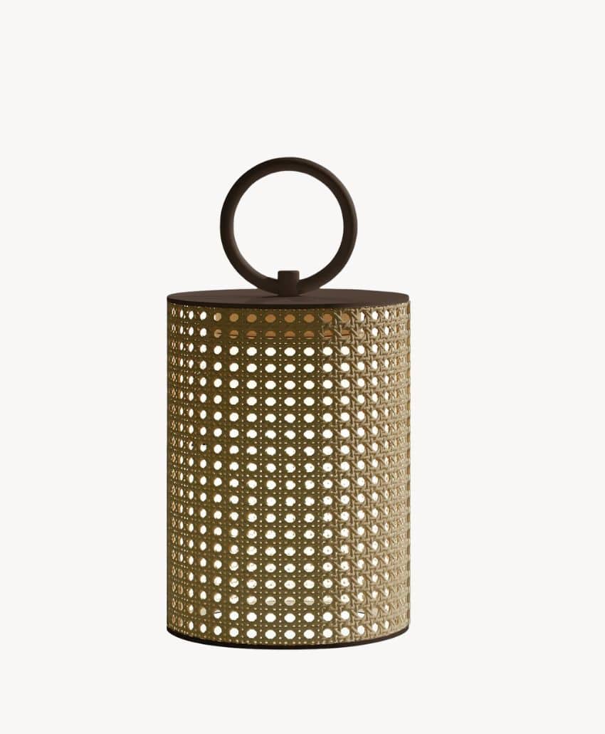 A cylindrical lantern with a woven rattan pattern and a solid dark top featuring a large circular handle, set against a plain white background.