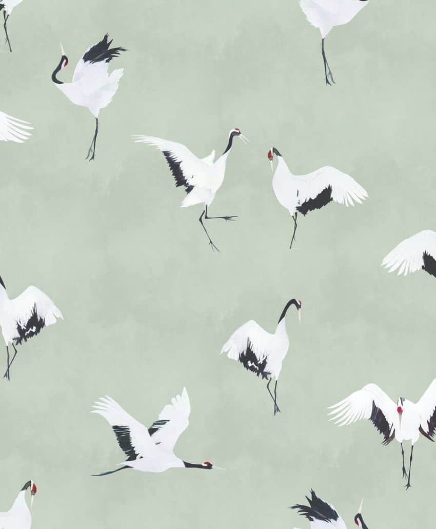 Illustrated white cranes with black wing tips and red crowns are shown flying and standing on a soft, pale green background in a repeating pattern.