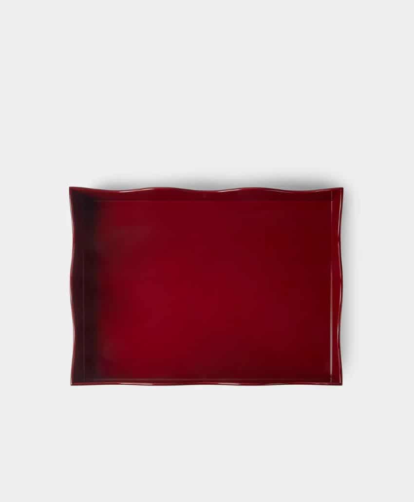 A rectangular, deep red tray with slightly wavy edges is displayed on a plain light gray background.