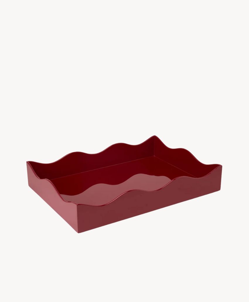 A rectangular, deep red tray with wavy, scalloped edges, displayed on a plain white background.