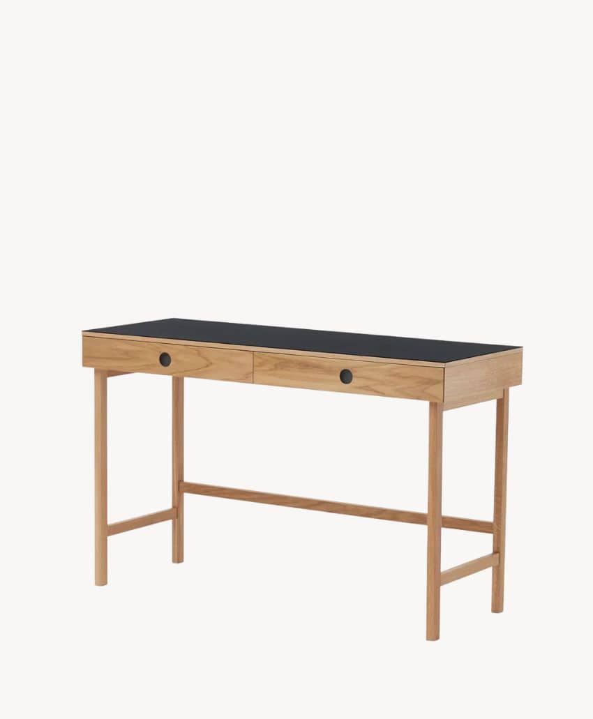 A wooden desk with a light wood frame, two black drawers with round knobs, and a black tabletop, set against a plain white background.