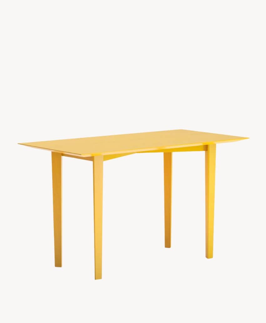 A modern, rectangular yellow table with four straight legs and a slightly angled tabletop, set against a plain white background.