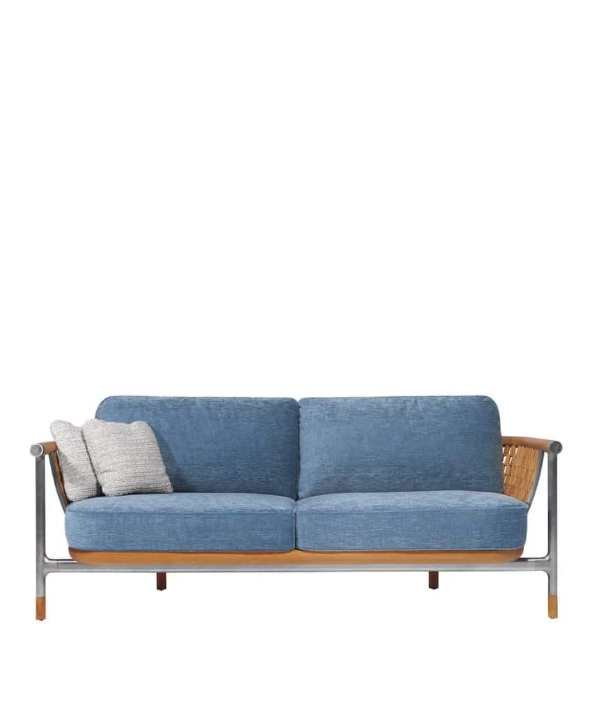 A modern blue sofa with wooden armrests and frame, featuring two large blue cushions and two light gray throw pillows placed on the left side.