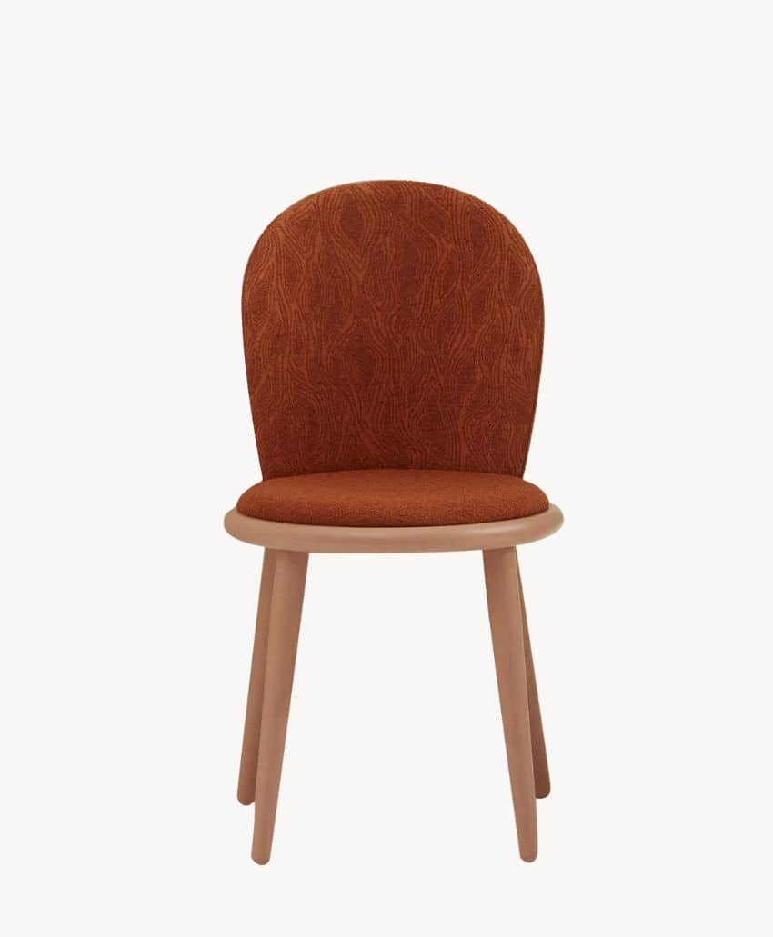 A modern chair with a rounded, rust-colored upholstered backrest and seat, featuring subtle textured patterns. The chair has four light wooden legs and a smooth, light wood frame.