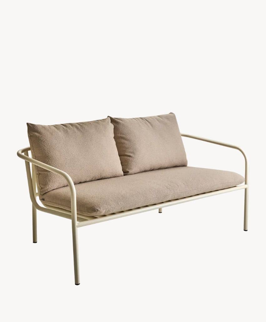 A modern loveseat with a cream-colored metal frame, featuring beige cushions and two matching backrest pillows, set against a plain white background.