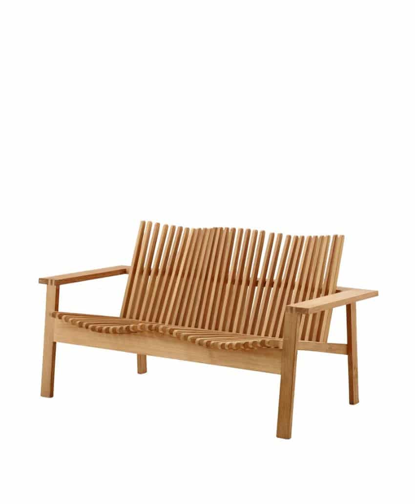 A modern wooden bench with angled slats forming the backrest and seat, featuring wide armrests and a minimalist design. The bench is shown on a plain white background.