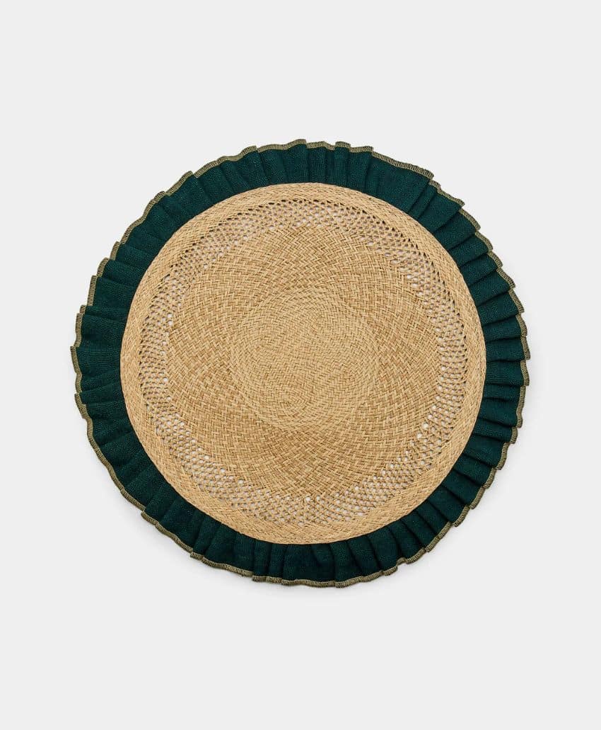A round woven straw placemat with a dark green ruffled fabric border, displayed on a plain light background.