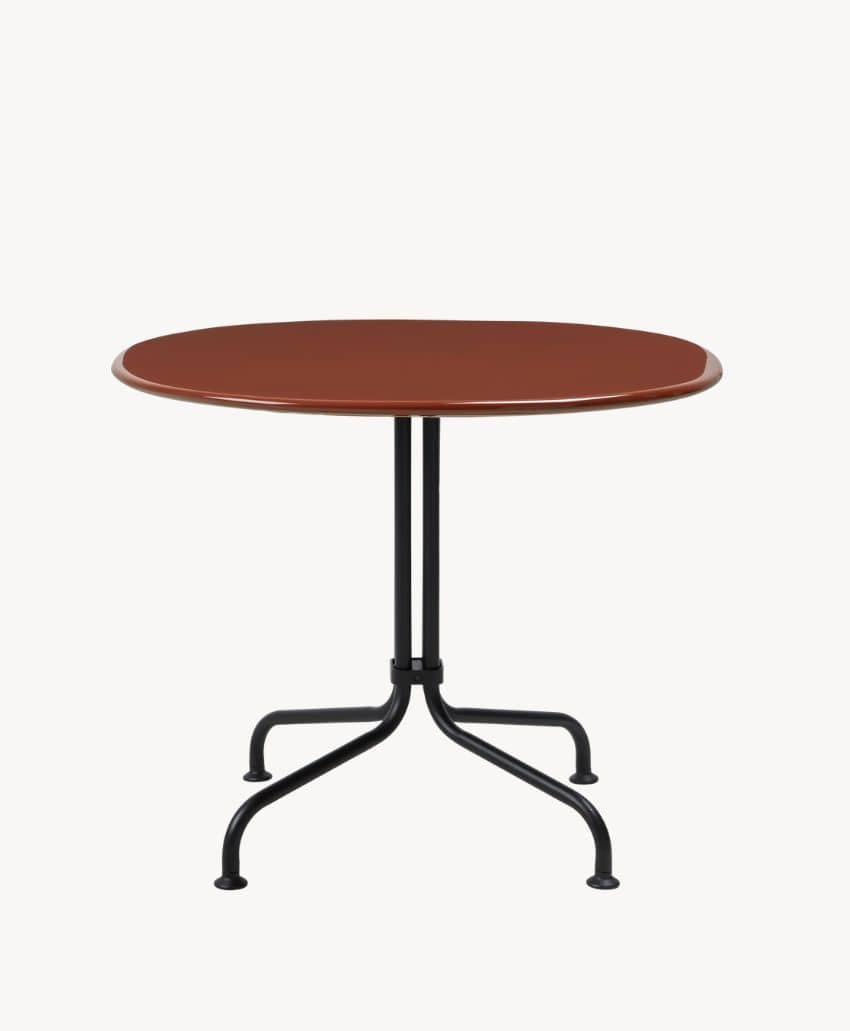 A round, brown table with a smooth surface and a black metal base featuring four curved legs, set against a plain white background.