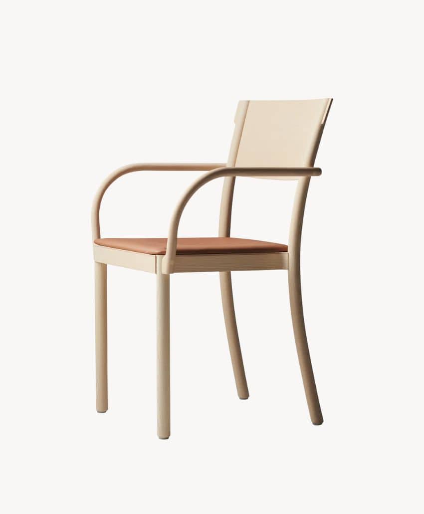 Minimalist beige chair with curved armrests and a light brown seat cushion, set against a plain white background.