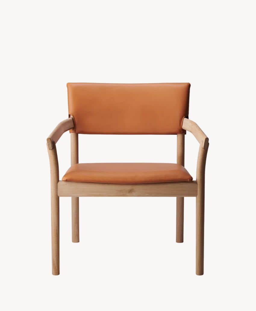 A modern wooden chair with a light oak frame and tan leather seat and backrest, photographed against a plain white background.