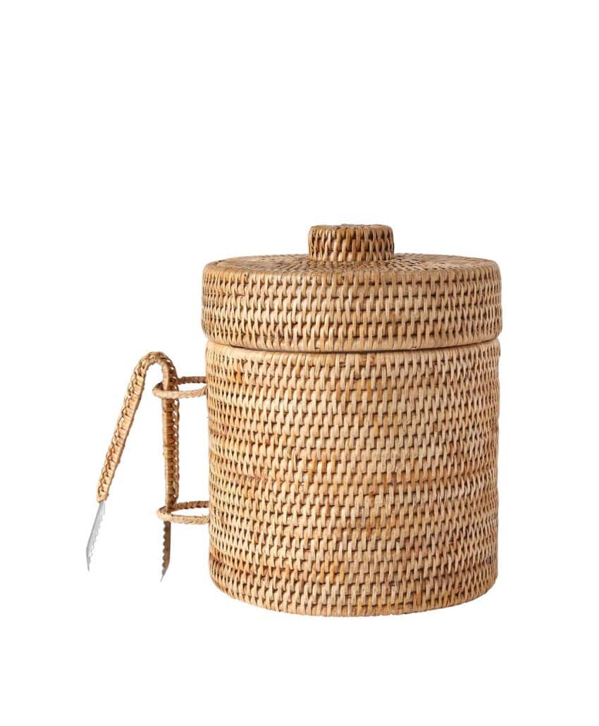 Round woven rattan ice bucket with a matching lid and handle, shown with metal ice tongs attached to the side. The background is plain white.