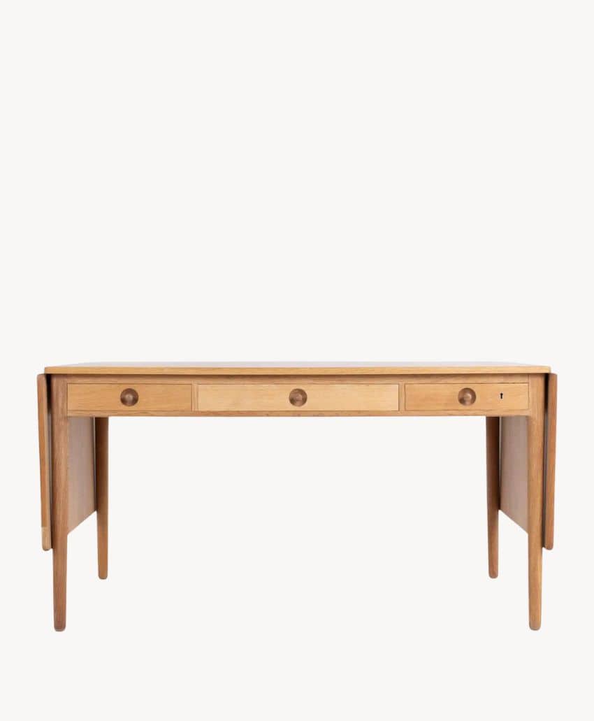 A wooden desk with three front drawers and drop-leaf extensions on both sides, shown against a plain white background.