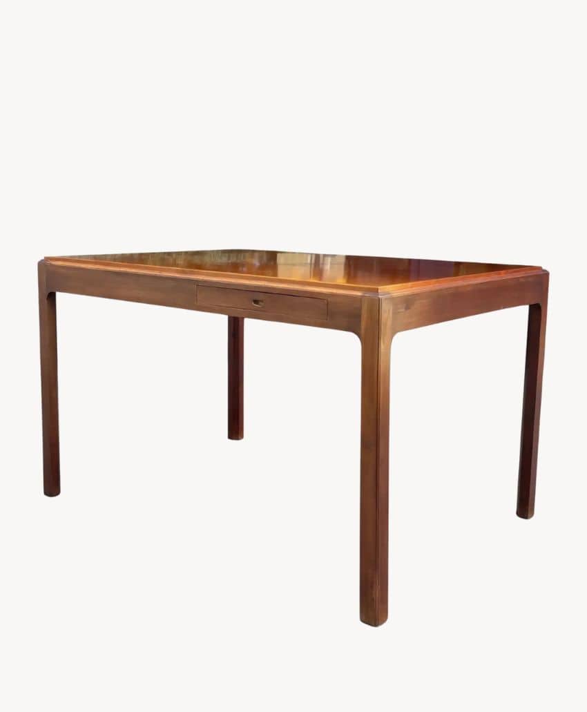 A rectangular wooden table with rounded edges and slim, straight legs, set against a plain white background.
