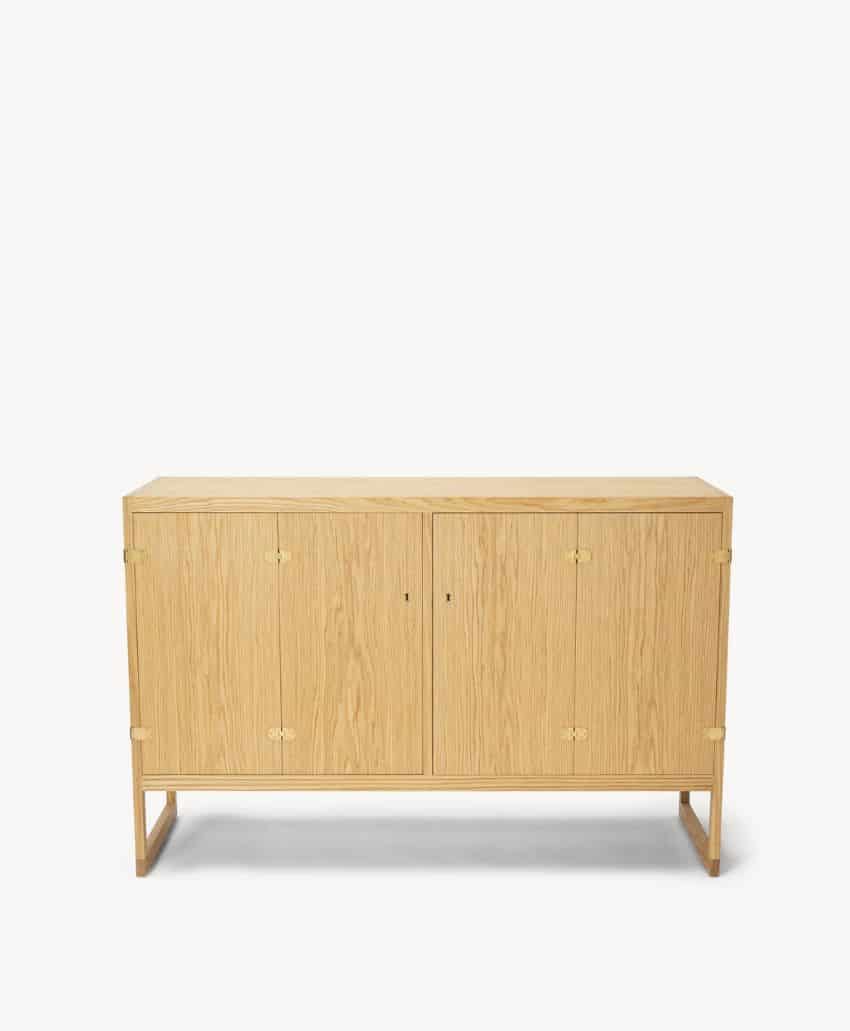 Light wood sideboard with four doors, simple rectangular design, subtle wood grain, and a minimalistic frame with open legs against a plain white background.