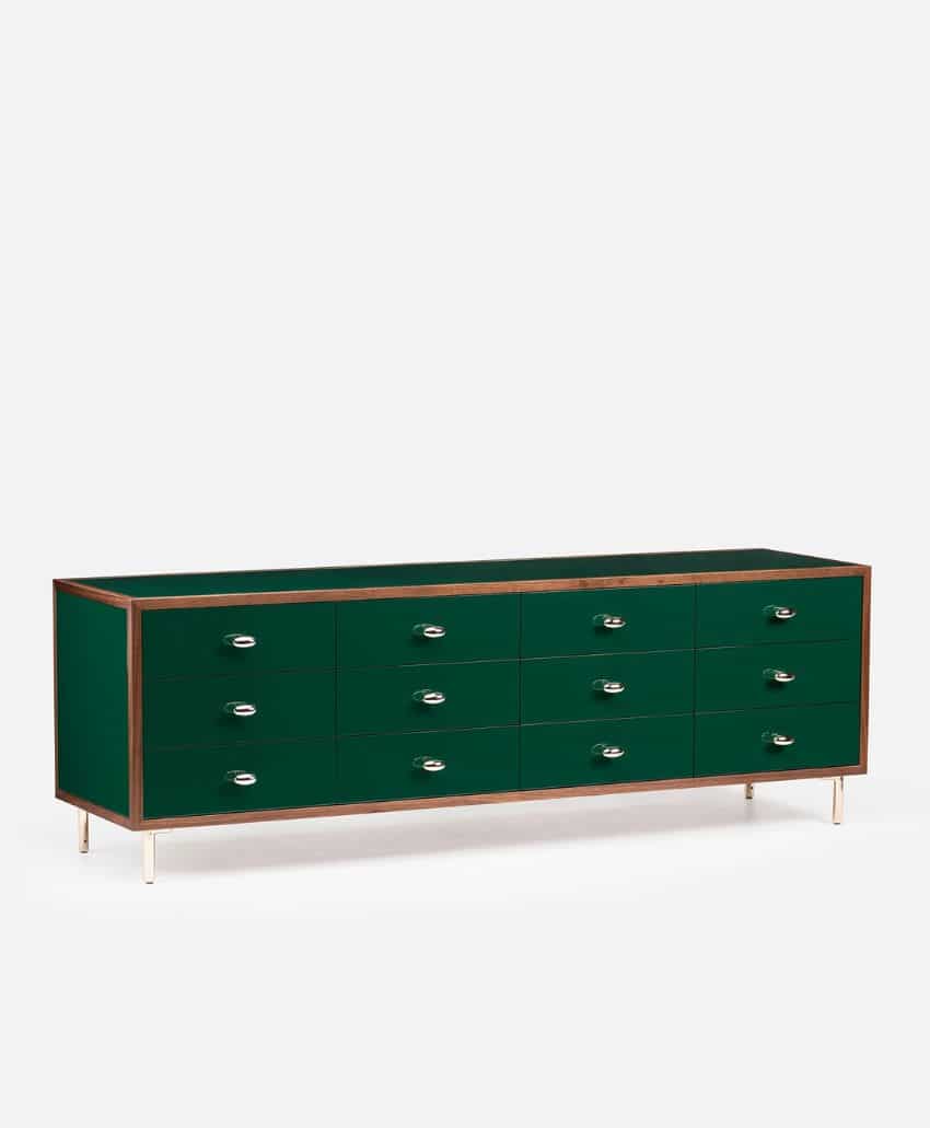 A modern dresser with a glossy dark green finish, featuring three rows of four drawers each, silver handles, light wood trim, and slender metal legs, set against a plain white background.