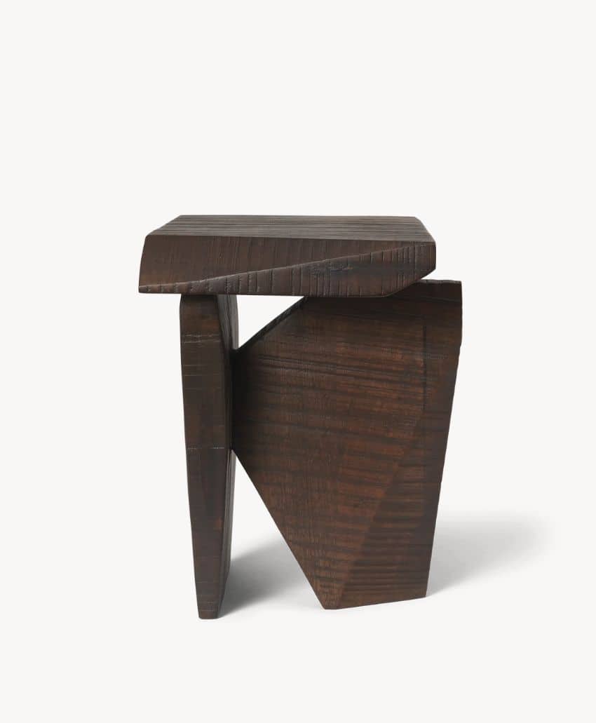 A dark wooden stool with an abstract, geometric design featuring angled legs and a thick, unevenly shaped seat, set against a plain white background.