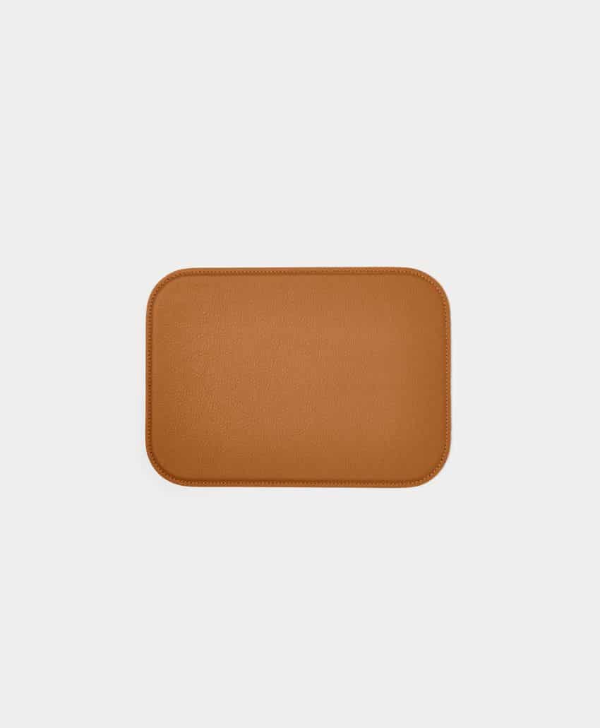 Rectangular, light brown leather desk pad with rounded corners, placed on a plain light gray background.