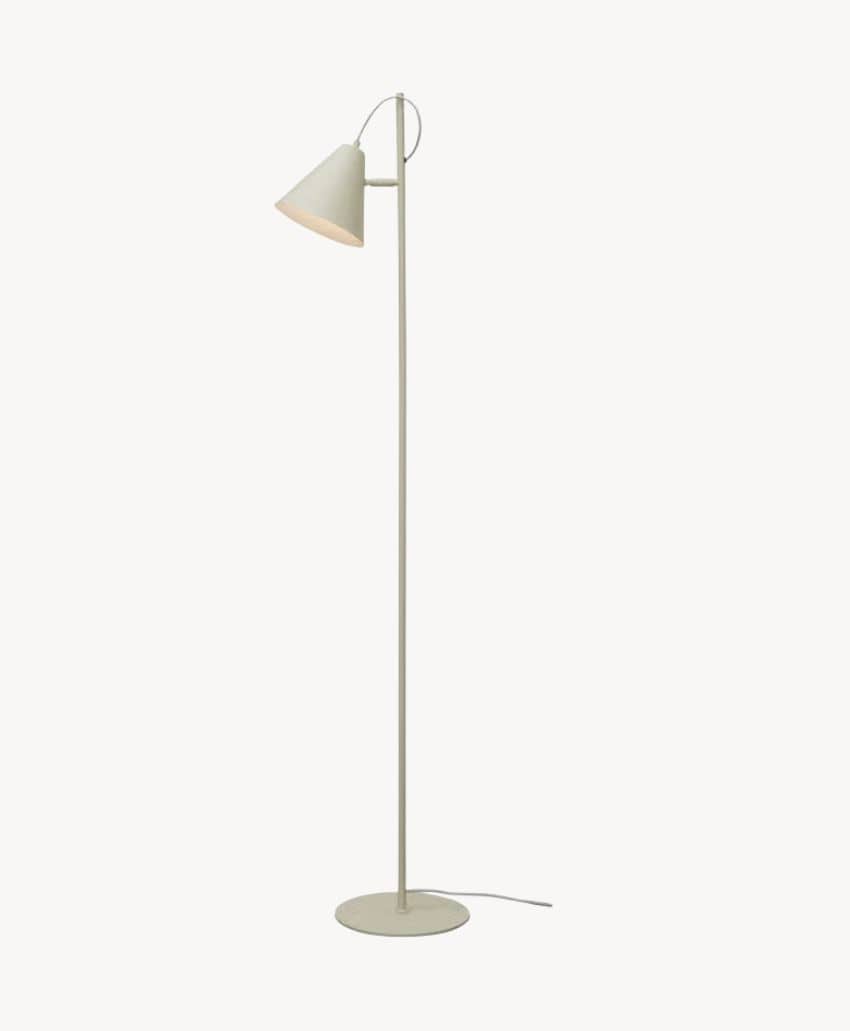 Minimalist beige floor lamp with a round base, slim vertical stand, and an angled conical shade. A power cord extends from the base, and the lamp is set against a plain white background.