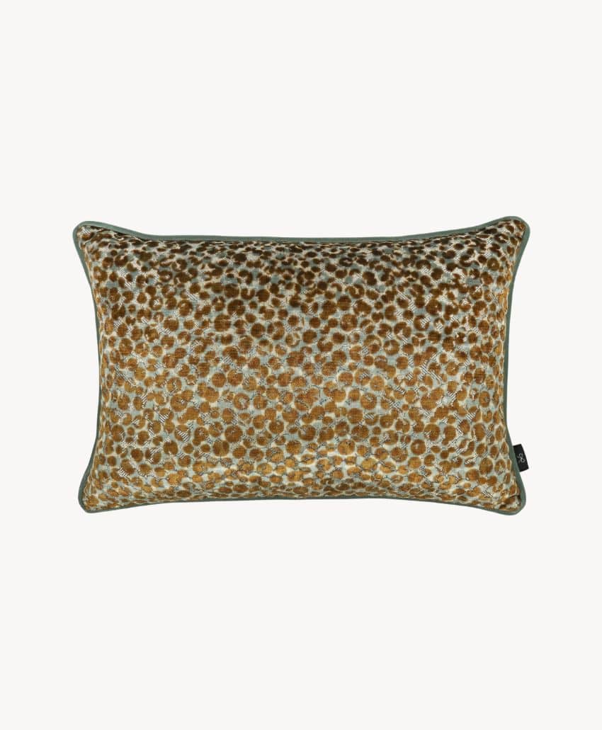 Rectangular throw pillow with a leopard print pattern in shades of gold and brown, bordered by a thin green piping, set against a plain white background.