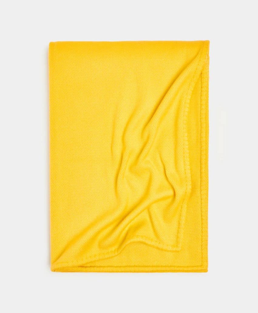 A neatly folded yellow cloth or microfiber towel with one corner slightly turned up, placed on a plain white background.