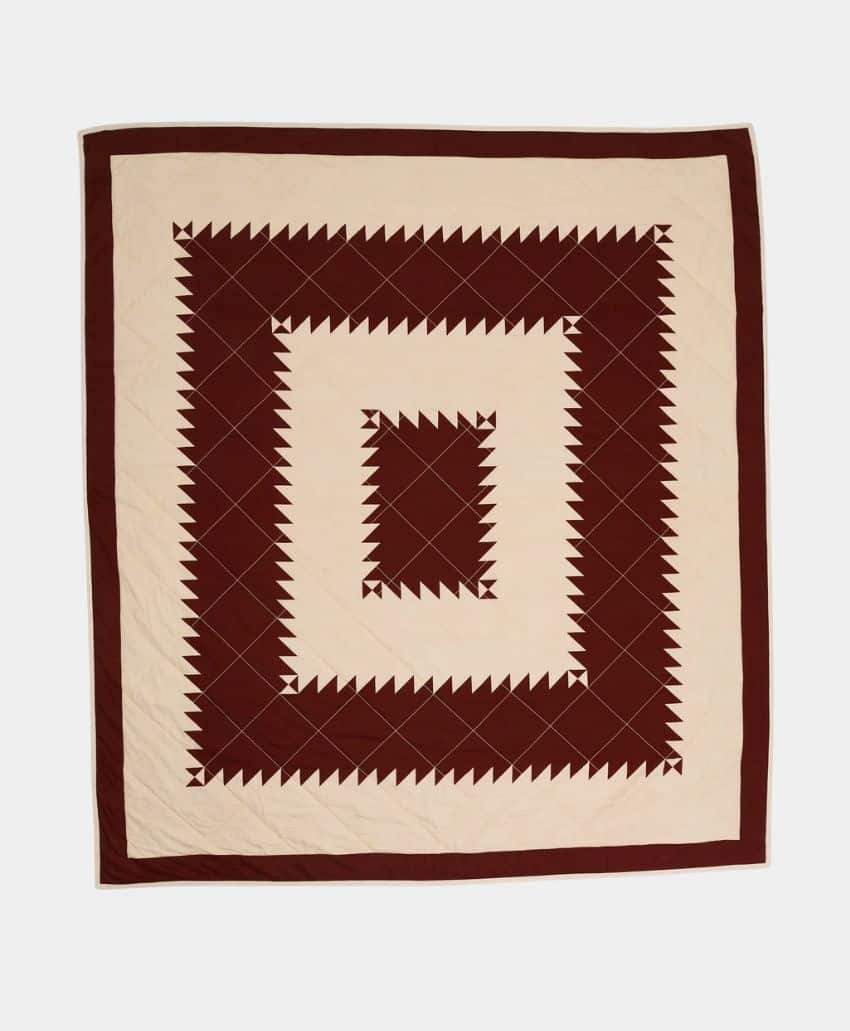 A close-up of a soft, cream-colored fabric with fringed edges, slightly wrinkled and folded, creating a cozy and textured appearance.