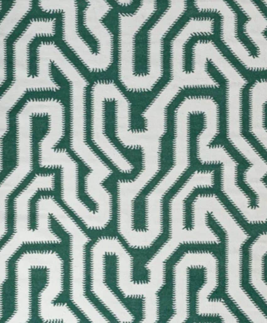 Abstract green and white geometric pattern with interconnected, maze-like lines and sharp, jagged edges forming repeating shapes on a light background.