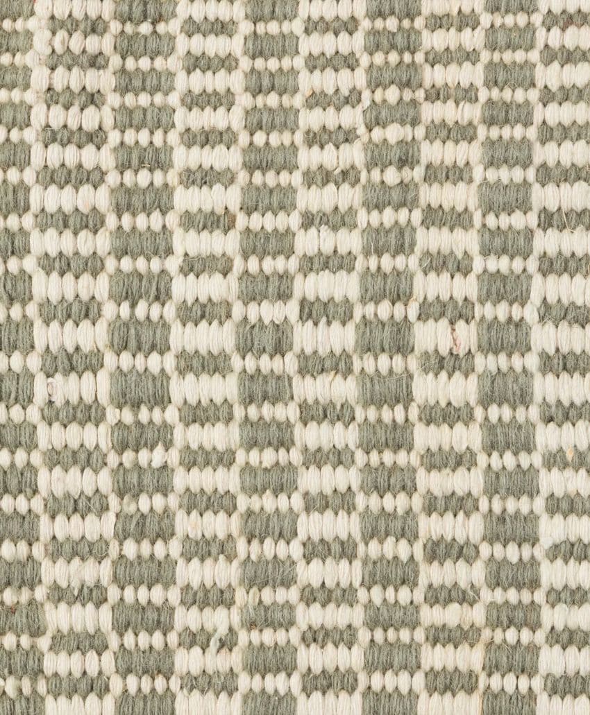 Close-up of a woven fabric with a textured pattern of alternating vertical stripes in off-white and grayish-green yarn. The pattern consists of small, raised loops and flat sections.