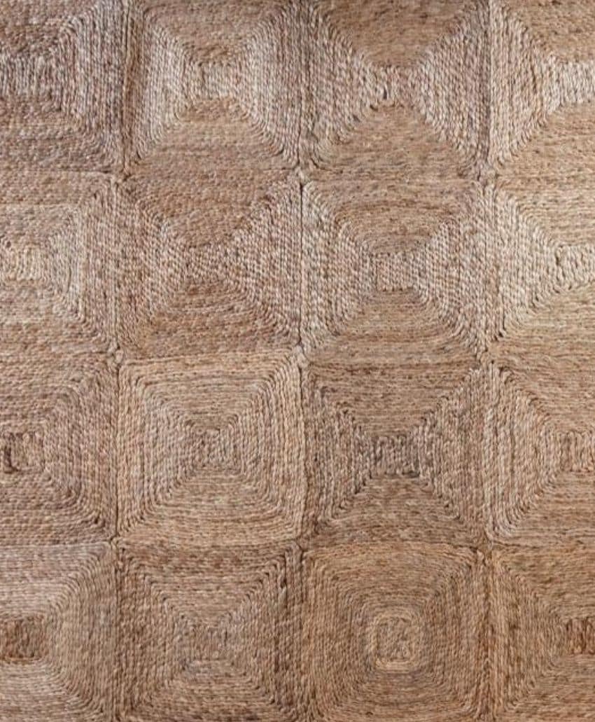 Close-up of a woven surface with a geometric square pattern, featuring varying shades of natural brown and tan fibers, creating a textured, rustic appearance.