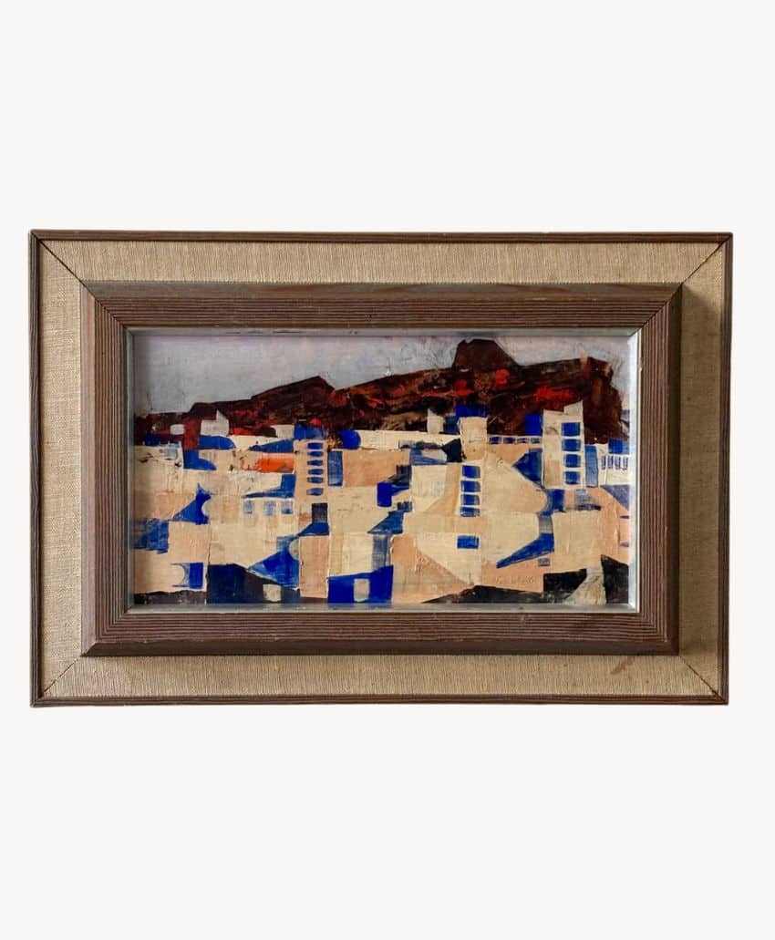 Framed artwork featuring an abstract cityscape with beige, blue, and brown geometric shapes and a reddish mountain range in the background.