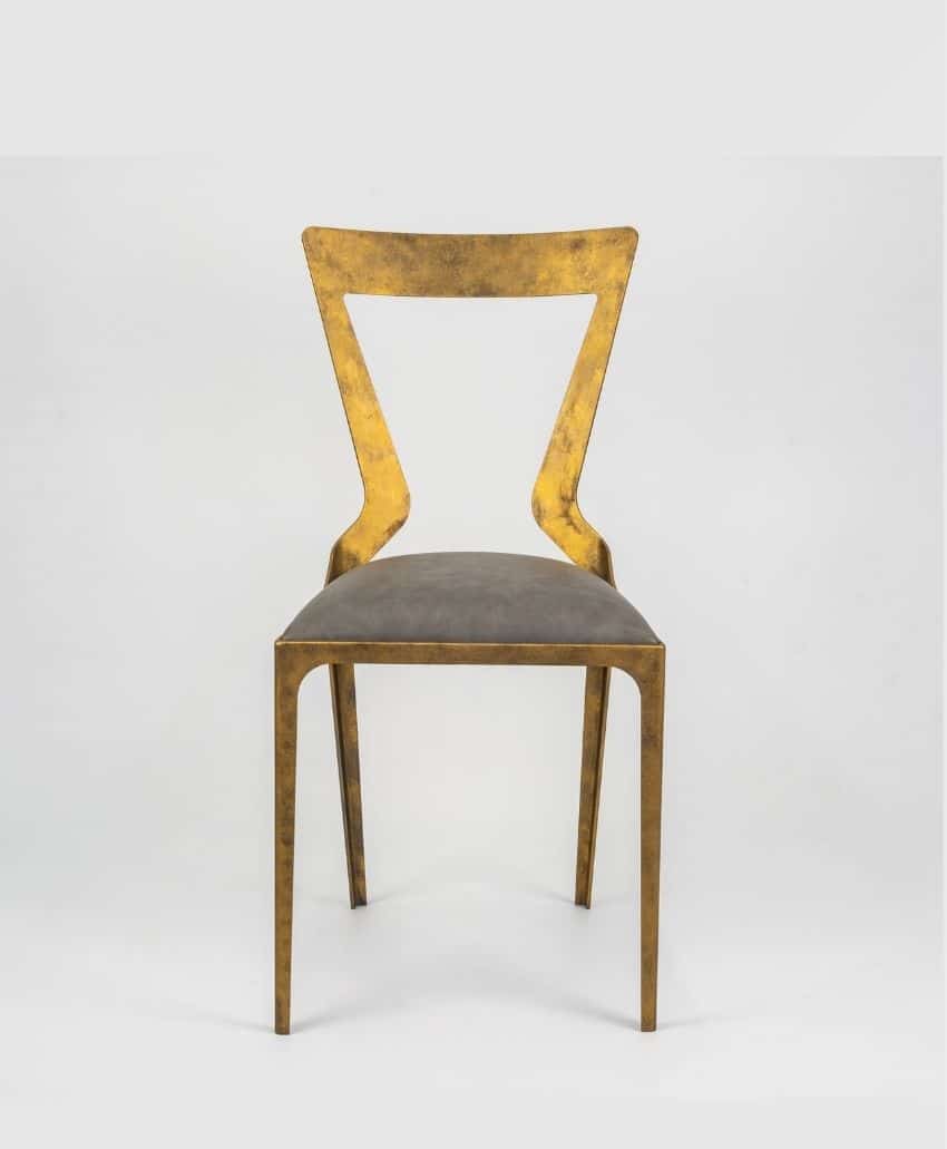 A modern chair with a gold metal frame, Z-shaped backrest, and a gray cushioned seat, set against a plain white background.