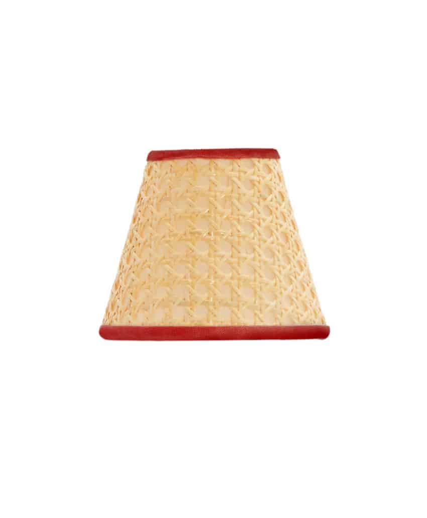 A woven rattan lampshade with a conical shape and red trim along the top and bottom edges, set against a plain white background.
