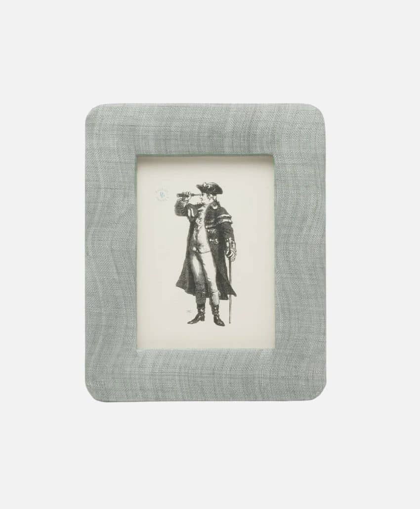 A light gray rectangular photo frame with a textured fabric finish displays a black and white illustration of a person in historical clothing looking through a telescope.