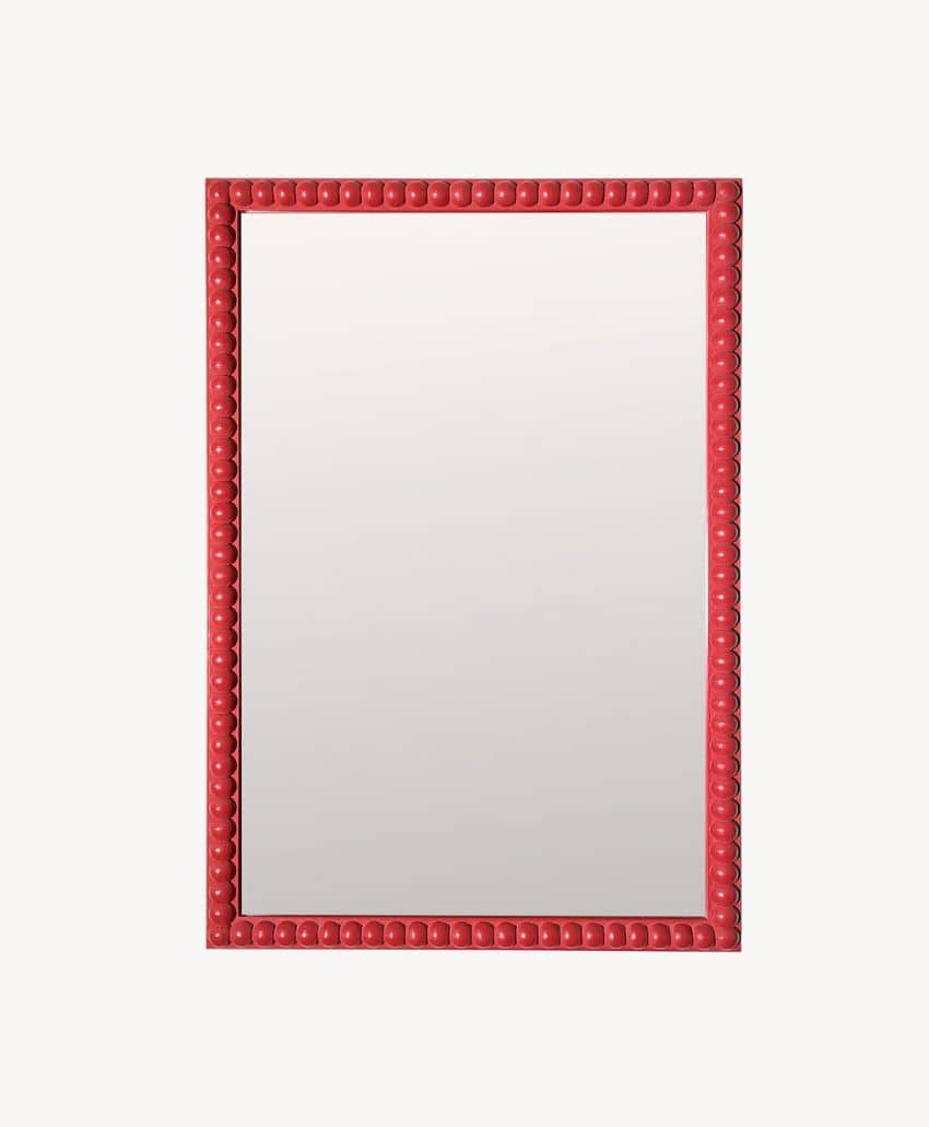A rectangular mirror with a bright red, beaded frame set against a plain white background.