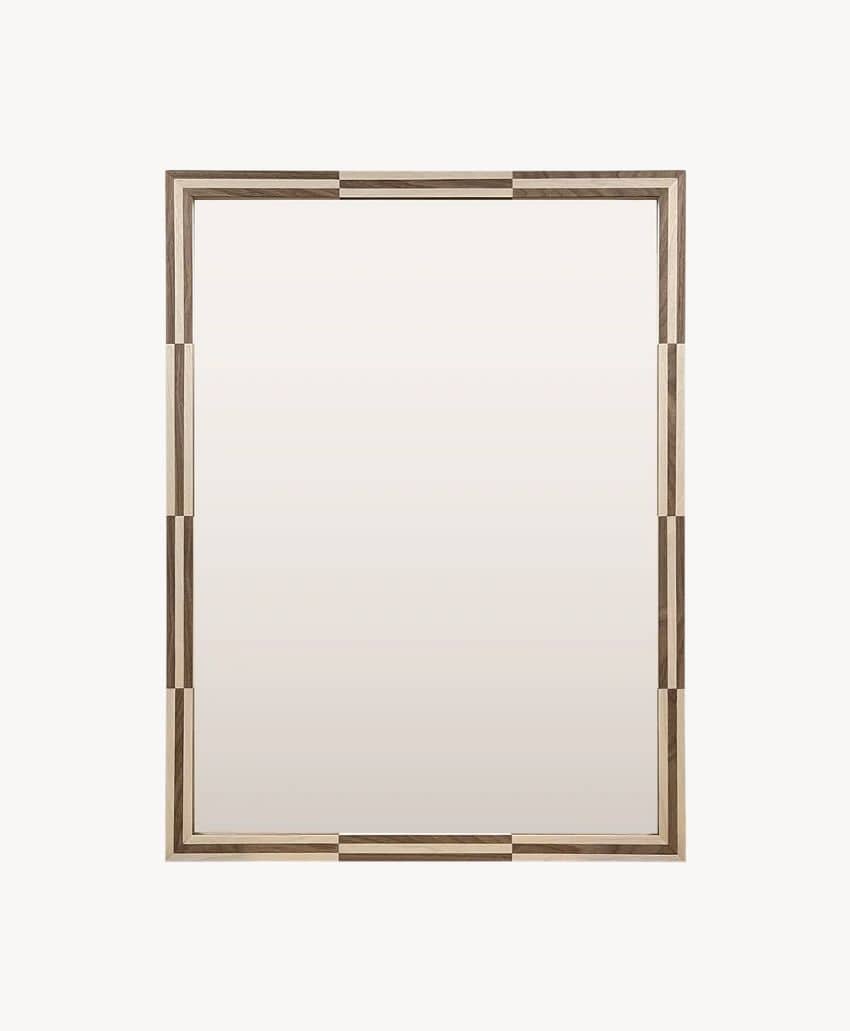A rectangular mirror with a wooden frame featuring alternating light and dark wood segments, creating a geometric pattern around the edges. The background is plain and light-colored.