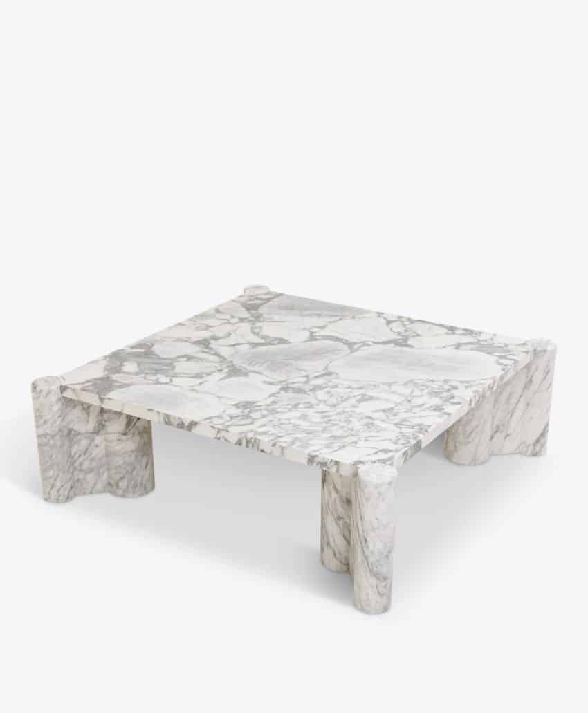 A square, low-profile coffee table made of white marble with gray veining, featuring thick, cylindrical legs at each corner, set against a plain white background.