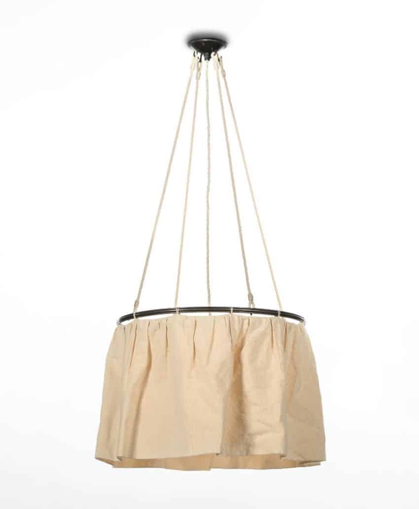 A hanging ceiling lamp with a pleated beige fabric shade, suspended by four white cords attached to a central black ceiling mount, against a plain white background.
