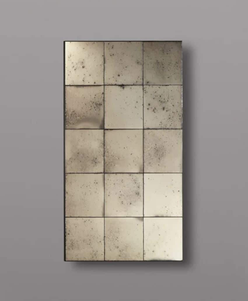 A rectangular panel composed of sixteen antique-style mirrored tiles arranged in a 4x4 grid, each tile featuring a distressed, speckled surface, mounted against a plain gray background.