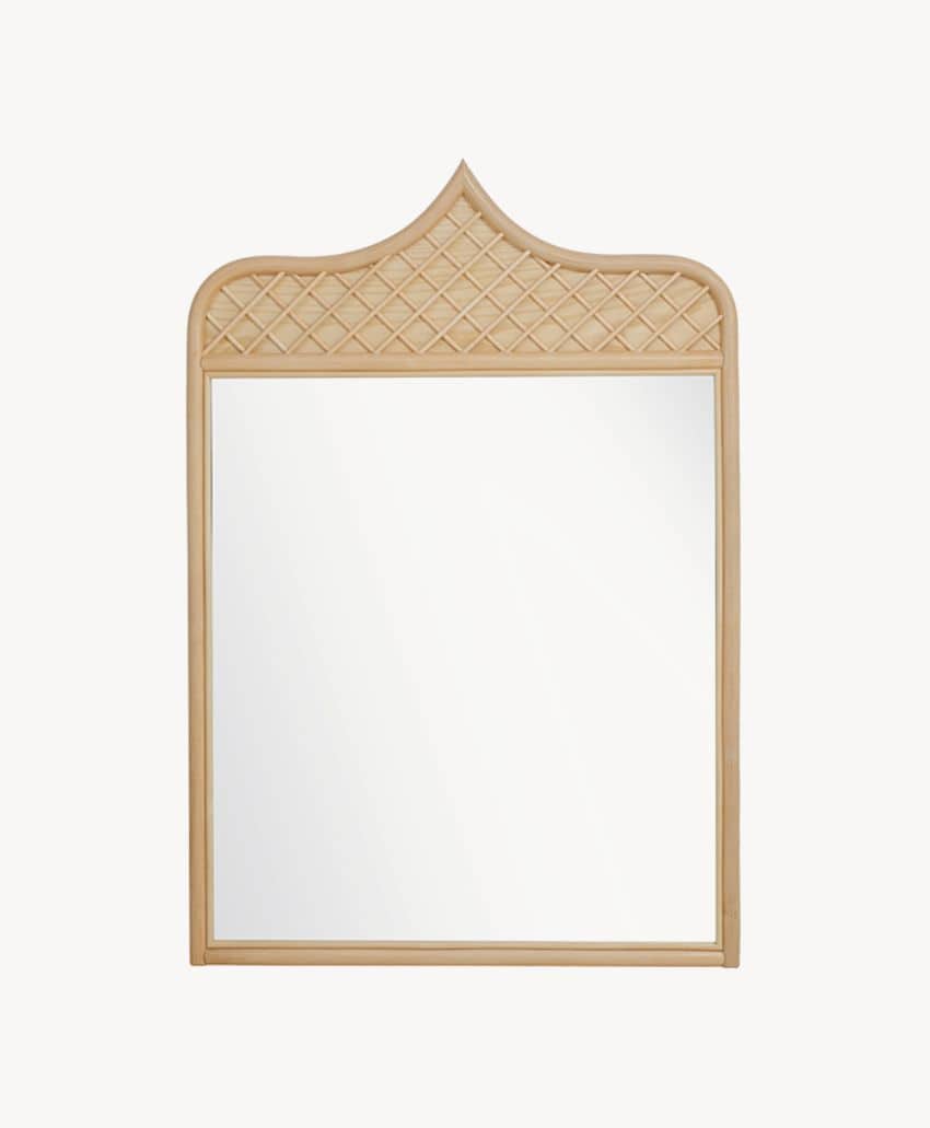 A rectangular mirror with a light wood frame featuring a pointed arch top and a crisscross lattice design on the upper section.