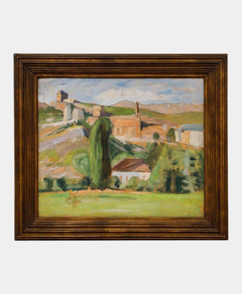 Framed painting depicting a landscape with rolling hills, green trees, and scattered buildings, including a church with a steeple and a house with a red roof, beneath a cloudy sky.