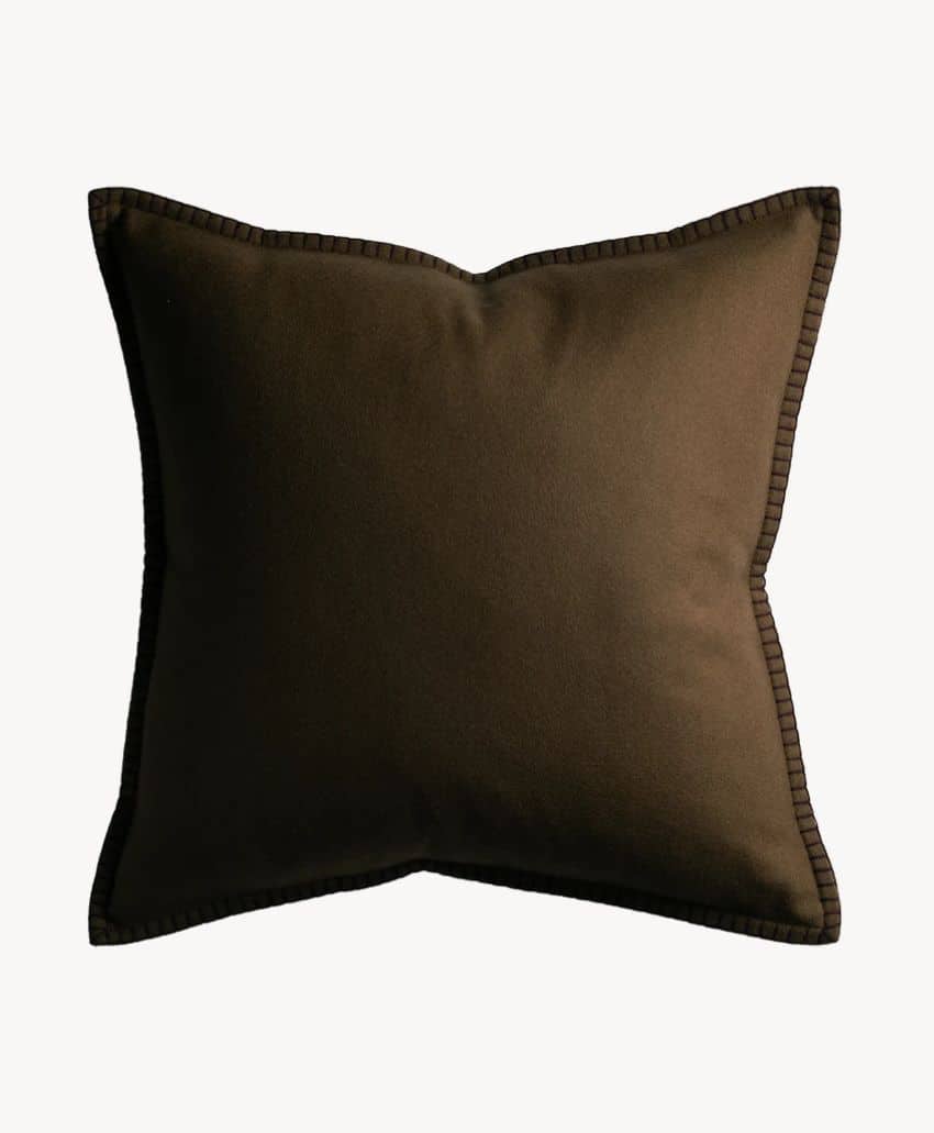 A square, brown throw pillow with a smooth fabric cover and stitched edges, set against a plain white background.