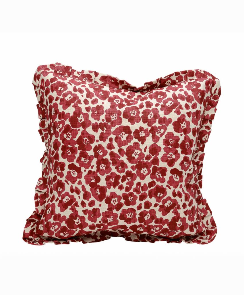 Square pillow with a red and white floral pattern, featuring scattered red flowers with white centers on a cream background. The pillow has a slightly wrinkled and soft appearance.